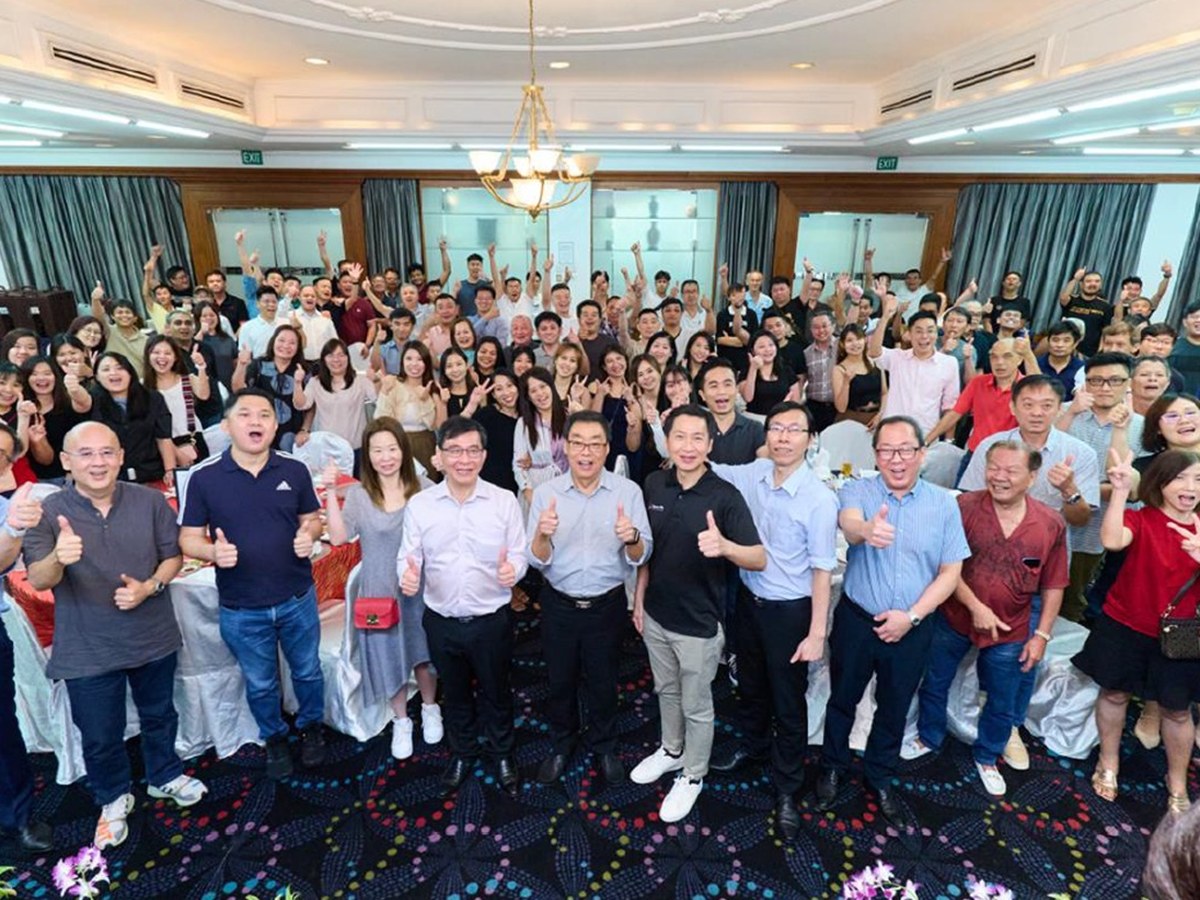 Soon Aik leaders and colleagues giving a thumbs up together at a company dinner